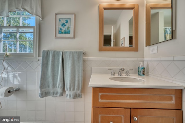 bathroom featuring vanity and tile walls