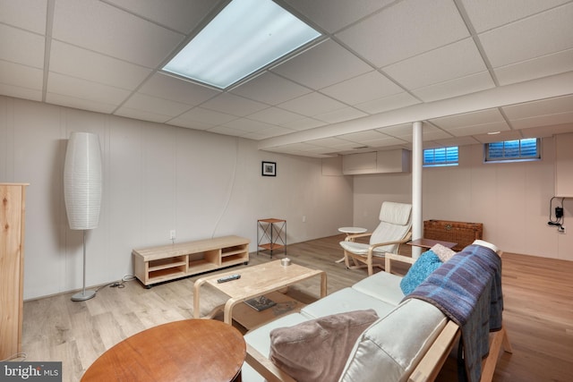 living room featuring a paneled ceiling and light hardwood / wood-style floors