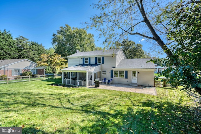 rear view of house featuring a patio, a yard, and a sunroom