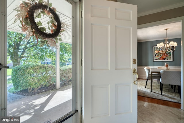 entryway with an inviting chandelier, plenty of natural light, and ornamental molding