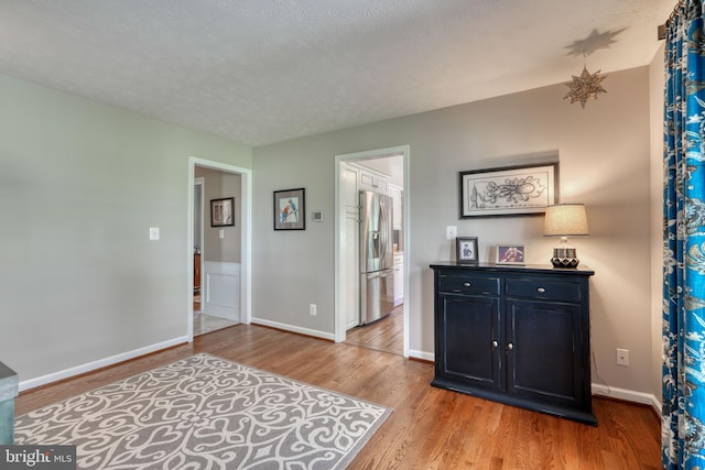 interior space with a textured ceiling and light hardwood / wood-style flooring