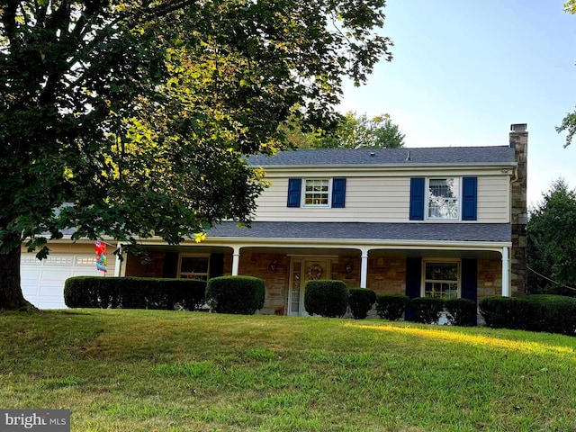 view of front of home featuring a garage, covered porch, and a front lawn