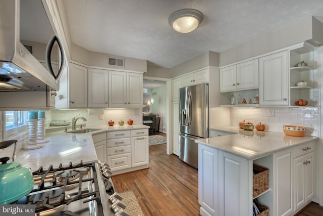 kitchen with stainless steel appliances, kitchen peninsula, and white cabinets