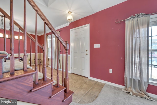 tiled entrance foyer with crown molding and a wealth of natural light