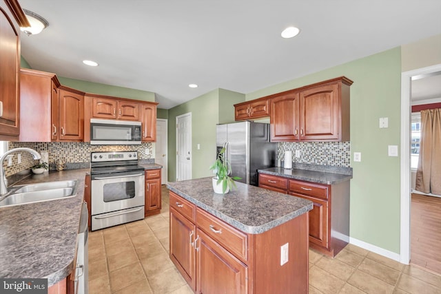 kitchen featuring sink, light tile patterned floors, appliances with stainless steel finishes, tasteful backsplash, and a kitchen island