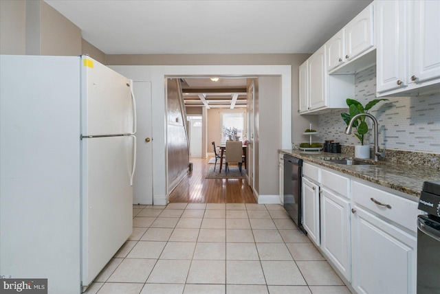 kitchen with white refrigerator, dark stone counters, black dishwasher, and white cabinets