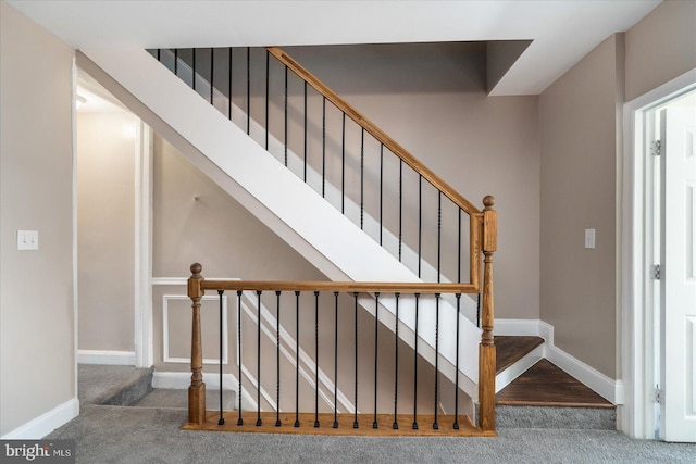 stairway featuring carpet flooring