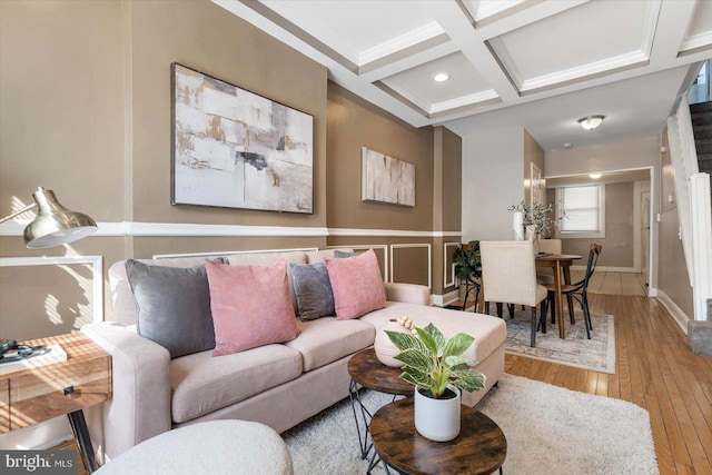 living room featuring coffered ceiling, wood-type flooring, ornamental molding, and beamed ceiling