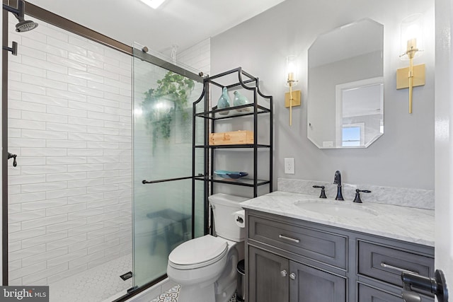 bathroom with vanity, a shower with door, and toilet