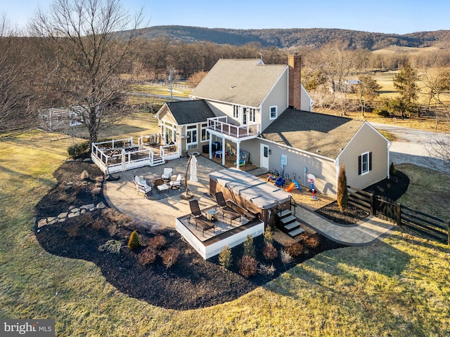 rear view of house featuring a lawn, an outdoor living space with a fire pit, and a patio area