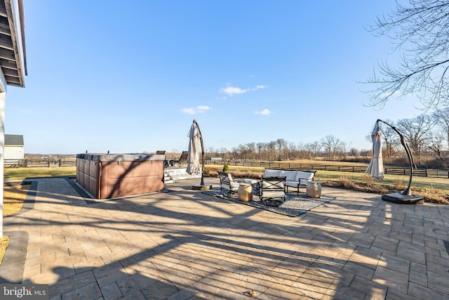 view of patio featuring a rural view and a hot tub