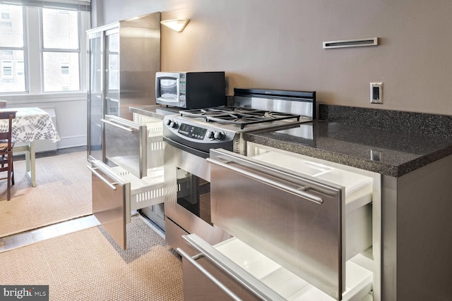 kitchen with carpet floors and stainless steel range with gas cooktop