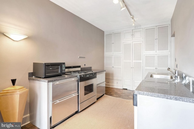 kitchen with stainless steel gas stove, sink, and track lighting