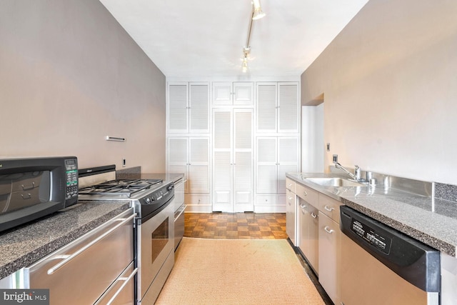 kitchen with sink, light parquet floors, and appliances with stainless steel finishes