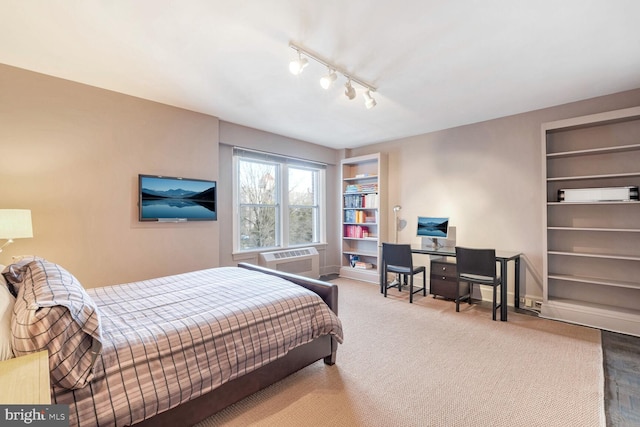 carpeted bedroom featuring rail lighting and a wall mounted air conditioner