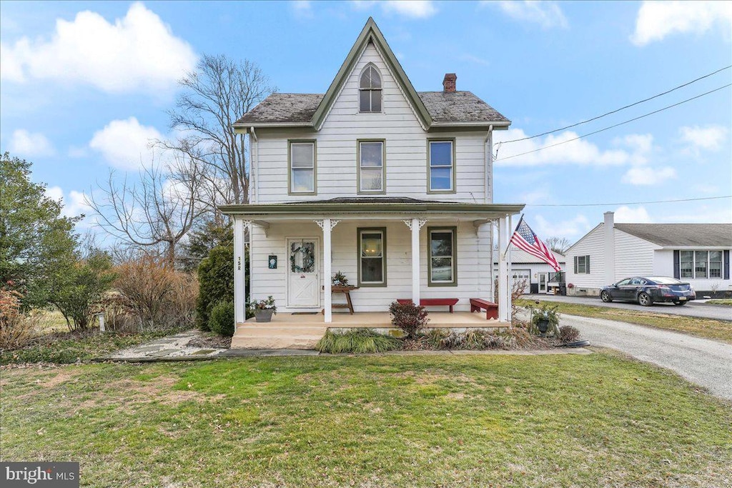 view of front of home featuring a front yard and a porch