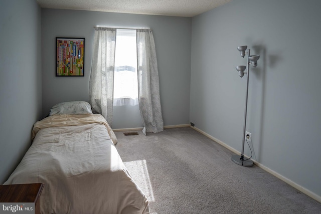 carpeted bedroom featuring a textured ceiling