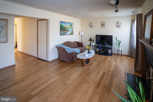 living room with a textured ceiling and light hardwood / wood-style floors