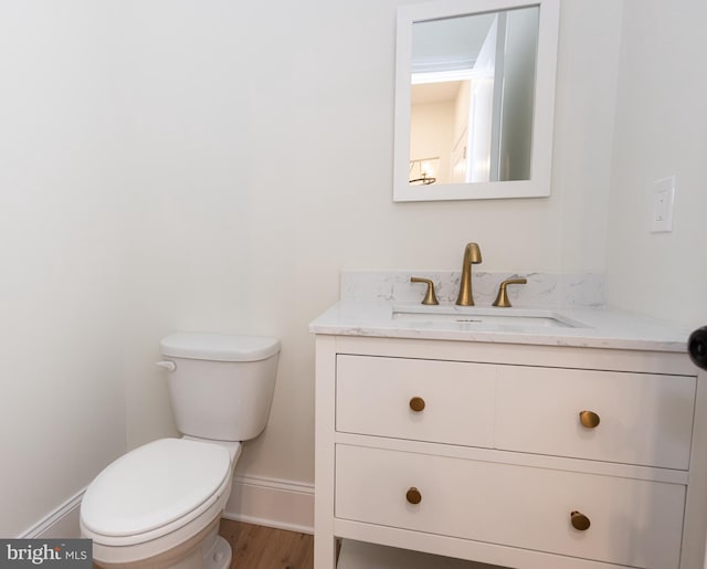 bathroom with vanity, toilet, and wood-type flooring