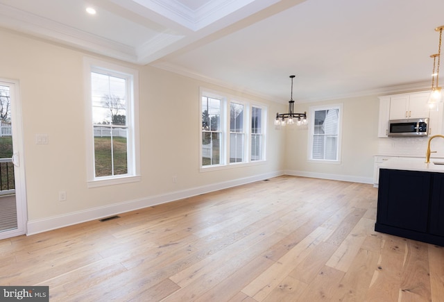 unfurnished dining area featuring beam ceiling, light hardwood / wood-style flooring, ornamental molding, and a chandelier