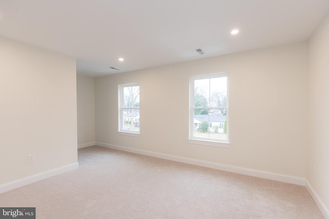 spare room featuring light colored carpet