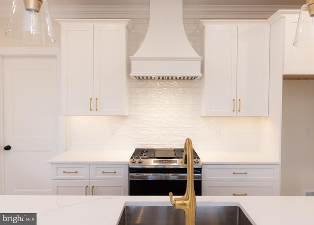 kitchen featuring tasteful backsplash, white cabinetry, custom range hood, and stainless steel gas stove