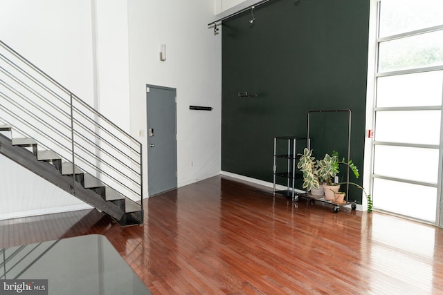 interior space featuring a towering ceiling and hardwood / wood-style floors