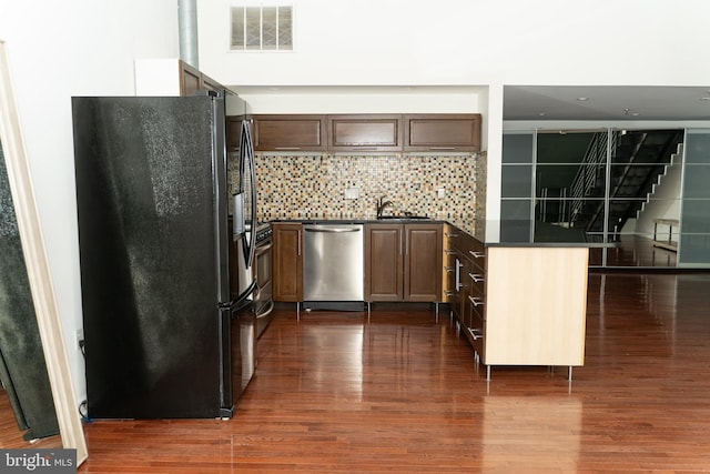 kitchen with tasteful backsplash, sink, dark wood-type flooring, and stainless steel appliances