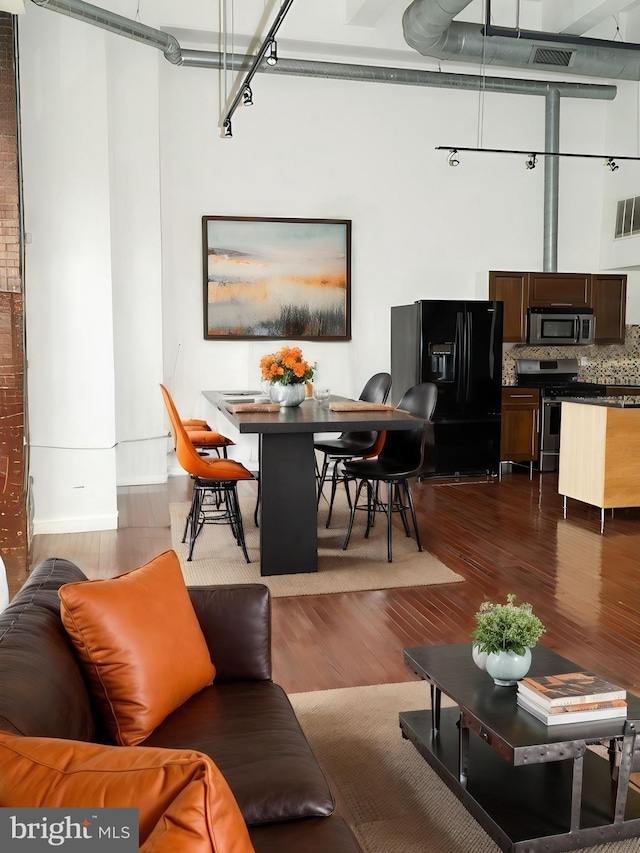 living room featuring a towering ceiling and hardwood / wood-style floors