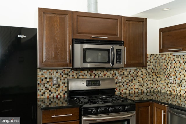 kitchen with appliances with stainless steel finishes and backsplash