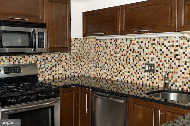 kitchen featuring appliances with stainless steel finishes, sink, backsplash, and dark brown cabinetry