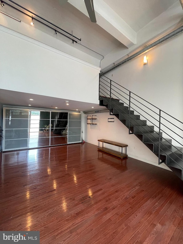 interior space with hardwood / wood-style flooring, track lighting, and a high ceiling