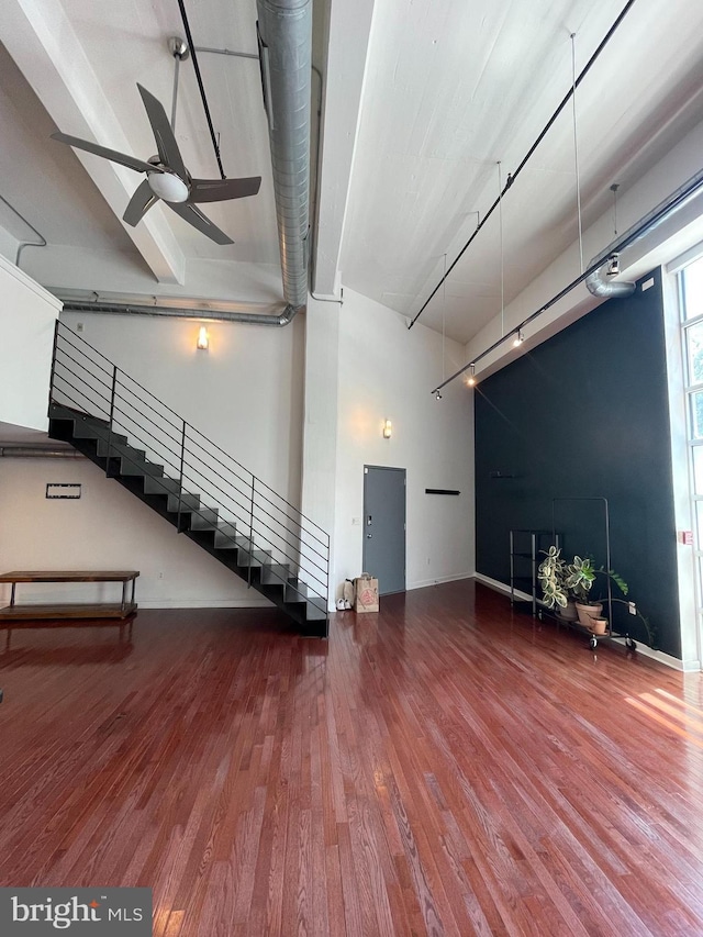 basement with hardwood / wood-style flooring, ceiling fan, and rail lighting