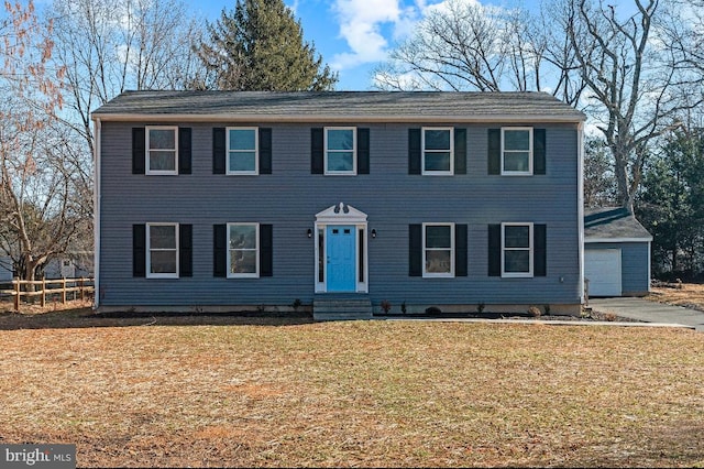 colonial home featuring a garage and a front lawn