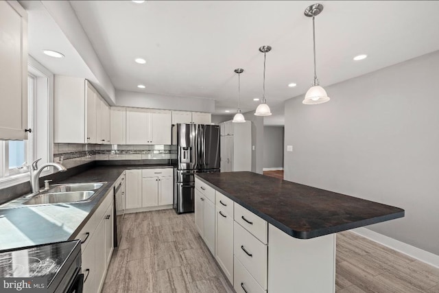 kitchen with stainless steel fridge with ice dispenser, sink, a center island, and white cabinets