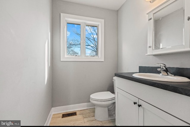 bathroom featuring vanity, toilet, and hardwood / wood-style floors