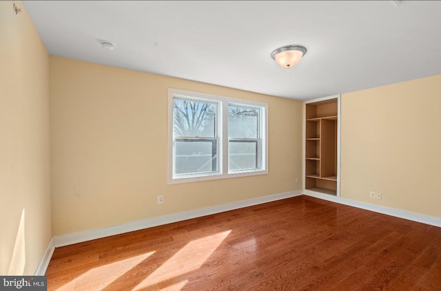 spare room featuring wood-type flooring