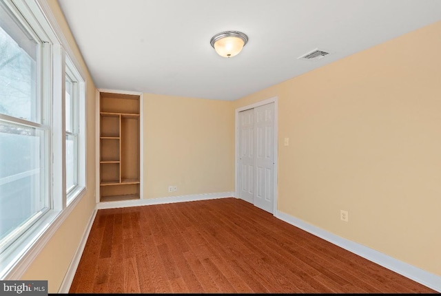 unfurnished bedroom with multiple closets and multiple windows