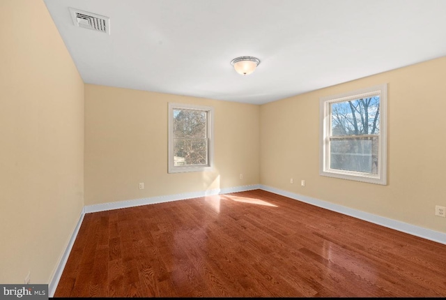 empty room featuring hardwood / wood-style flooring and a healthy amount of sunlight