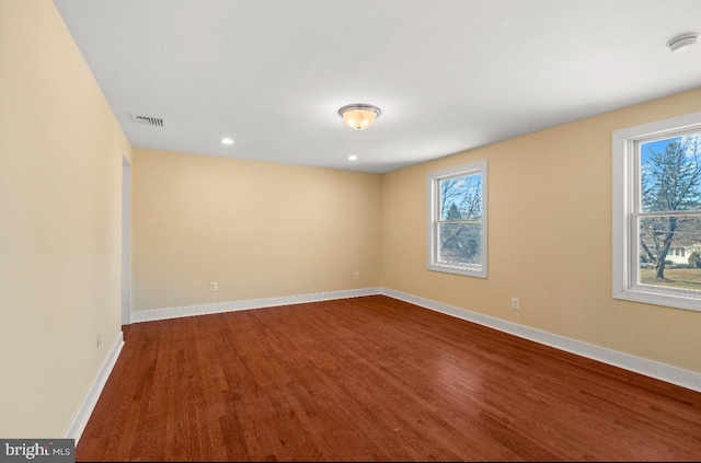 empty room with plenty of natural light and wood-type flooring