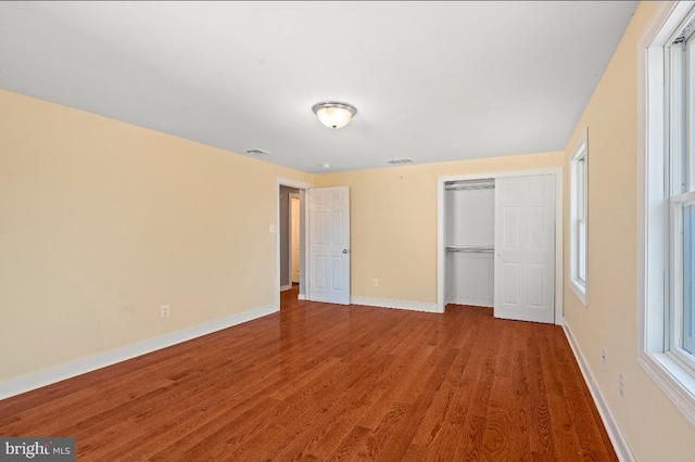 unfurnished bedroom with hardwood / wood-style flooring and a closet