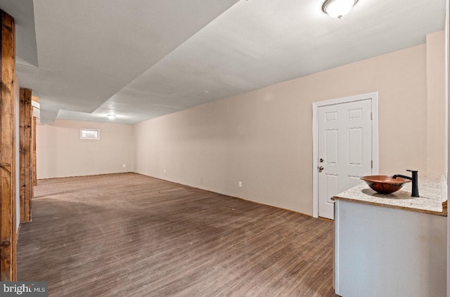 unfurnished living room featuring sink and hardwood / wood-style flooring