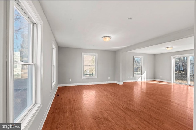 empty room with wood-type flooring and a wealth of natural light