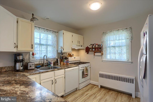 kitchen featuring sink, white appliances, light hardwood / wood-style flooring, white cabinetry, and radiator heating unit