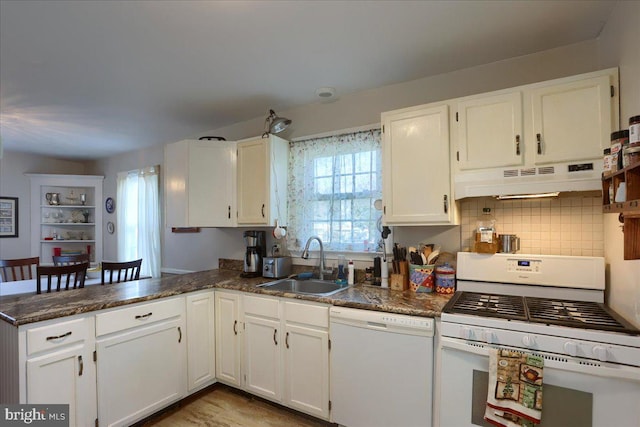 kitchen with white cabinetry, white appliances, kitchen peninsula, and sink