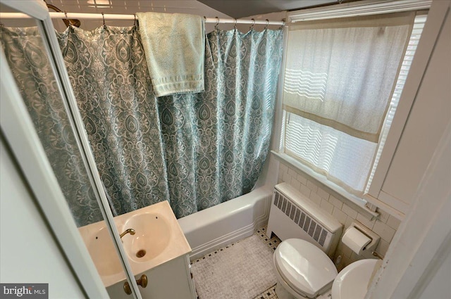 full bathroom with vanity, radiator heating unit, shower / bath combo, and a healthy amount of sunlight