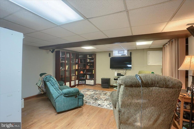 living room featuring a drop ceiling and light wood-type flooring