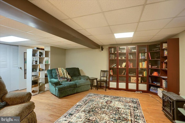 living room with hardwood / wood-style flooring and a paneled ceiling