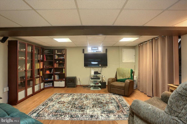 living room featuring wood-type flooring and a paneled ceiling