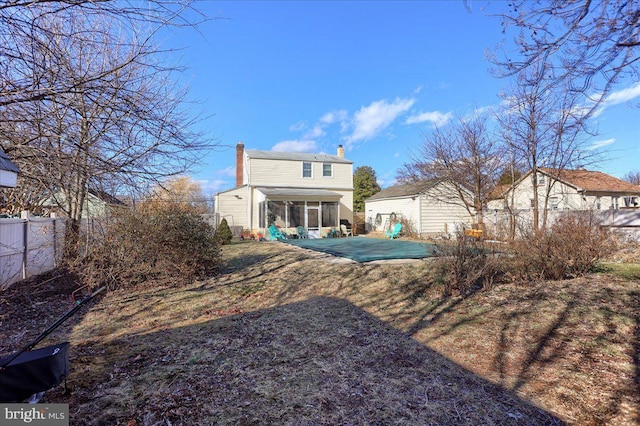 rear view of house featuring a sunroom and a patio